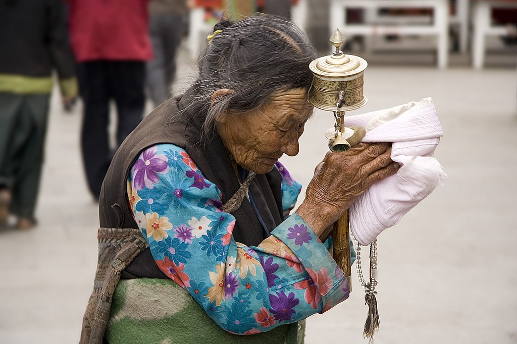 An elderly Tibetan women holding a prayer wheel on Lhasa, Barkhor